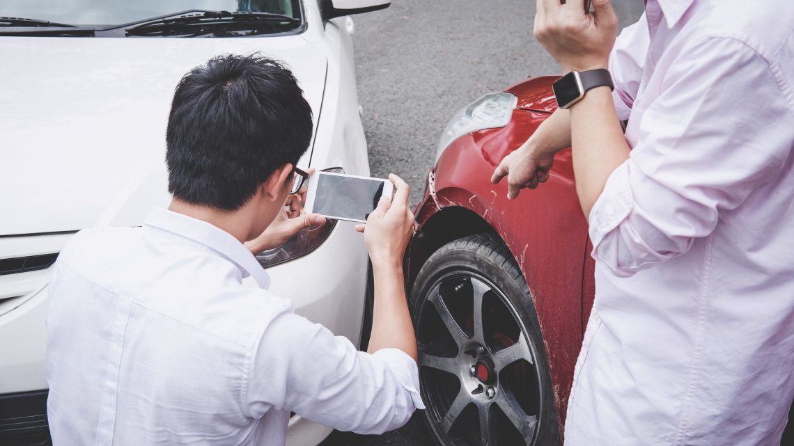 Two drivers man arguing after a car traffic accident collision and making phone call to Insurance Agent and take a photo, Traffic Accident and insurance concept.