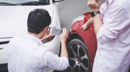 Two drivers man arguing after a car traffic accident collision and making phone call to Insurance Agent and take a photo, Traffic Accident and insurance concept.